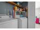 Laundry room with white washer and dryer and wire shelving with cleaning supplies at 248 Brookfield Cir, Sanford, NC 27330