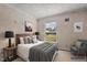 Staged bedroom with a large window, bed with side tables, and a chair at 2751 Old Fairground Rd, Angier, NC 27501