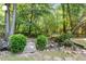 Landscaped backyard with mature trees, lush greenery, and wooden bridge at 2812 Dahlgreen Rd, Raleigh, NC 27615