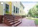 Backyard features brick steps leading up to a yellow home with manicured garden and brick-paved patio at 2812 Dahlgreen Rd, Raleigh, NC 27615