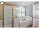 Bathroom featuring a glass-enclosed shower and soaking tub under a window at 2812 Dahlgreen Rd, Raleigh, NC 27615