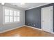 Bedroom with wood floors, gray walls, and a large window with white trim at 2812 Dahlgreen Rd, Raleigh, NC 27615
