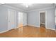 Open bedroom with light blue walls, wood floors, and multiple doorways at 2812 Dahlgreen Rd, Raleigh, NC 27615