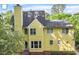 Bright yellow two-story home, featuring ample windows and mature trees at 2812 Dahlgreen Rd, Raleigh, NC 27615