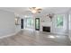 Open-concept living room boasts grey hardwood floors, fireplace, and large windows, perfect for entertaining at 2812 Dahlgreen Rd, Raleigh, NC 27615
