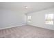 Bright bedroom with two windows, neutral walls, and carpeted flooring exudes simple elegance at 296 Beacon Dr, Pittsboro, NC 27312