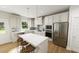Bright, modern kitchen features white cabinetry, stainless steel appliances and an island with bar seating at 296 Beacon Dr, Pittsboro, NC 27312