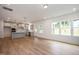 Open-concept living room with hardwood floors, a kitchen, and large windows at 296 Beacon Dr, Pittsboro, NC 27312