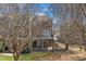 Back view of a brick two-story home with a covered patio and balcony, overlooking a well-maintained yard at 3001 Imperial Oaks Dr, Raleigh, NC 27614