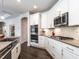 Modern kitchen featuring white cabinets, stainless steel appliances, and a stylish island with barstool seating at 3009 Kildaire Dairy Way, Apex, NC 27539