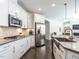 Well-equipped kitchen with stainless steel appliances, white cabinets, and an island with sink at 3009 Kildaire Dairy Way, Apex, NC 27539