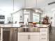 Open-concept kitchen island with stainless steel sink and access to dining and living areas at 3009 Kildaire Dairy Way, Apex, NC 27539