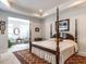 Elegant main bedroom features a four-poster bed, decorative rug, and sitting room at 3009 Kildaire Dairy Way, Apex, NC 27539