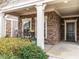 Inviting front porch with stone accents, decorative plants, and a cozy seating area at 3009 Kildaire Dairy Way, Apex, NC 27539