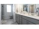 Elegant bathroom with gray cabinetry, dual sinks, and a walk-in shower at 3144 Star Gazing Ln, Durham, NC 27703