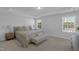 Spacious bedroom with tray ceiling, carpeted floor, two windows and an upholstered bench at 3360 Brevet St, New Hill, NC 27562