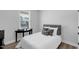 Well lit bedroom with a comfortable looking queen bed, side table, and view of the neighborhood through the window at 3360 Brevet St, New Hill, NC 27562