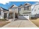 Charming two-story home featuring a two-car garage, landscaped front yard, and covered front porch at 3360 Brevet St, New Hill, NC 27562