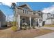 Two-story home featuring a welcoming front porch with two-car garage and professionally landscaped yard at 3360 Brevet St, New Hill, NC 27562
