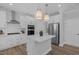 Stylish kitchen featuring white cabinets, stainless steel appliances, and an island with pendant lighting at 3360 Brevet St, New Hill, NC 27562