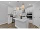 Bright, white kitchen with quartz countertops, stainless steel appliances, and pendant lighting above the island at 3360 Brevet St, New Hill, NC 27562