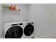 Bright laundry room featuring modern Whirlpool washer and dryer and wire shelving for storage at 3360 Brevet St, New Hill, NC 27562