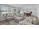 Open-concept living room seamlessly connects to the dining area with large windows and neutral decor at 3360 Brevet St, New Hill, NC 27562
