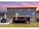 View of backyard featuring a wooden deck, patio with outdoor dining set, and well-maintained lawn at 3557 S Beaver Ln, Raleigh, NC 27604