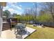 Backyard features a grill area, patio area, a fire pit, green grass, and a wooden fence at 3557 S Beaver Ln, Raleigh, NC 27604