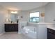 Bright bathroom with a modern soaking tub, vanity, and window providing natural light at 4026 Overcup Oak Ln, Cary, NC 27519