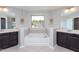 A full bath is showcased with double sinks, vanity, and tub at 4026 Overcup Oak Ln, Cary, NC 27519