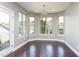 Bright breakfast nook with large windows, hardwood floors, stylish chandelier, and access to outdoor patio at 4026 Overcup Oak Ln, Cary, NC 27519