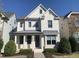Elegant two-story home with a painted brick facade, stylish front porch, and manicured landscaping at 4026 Overcup Oak Ln, Cary, NC 27519