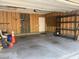 Empty garage with wood walls, concrete floor, and storage shelves at 4026 Overcup Oak Ln, Cary, NC 27519