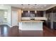 Elegant kitchen featuring dark cabinets, granite countertops, stainless steel appliances, and a central island at 4026 Overcup Oak Ln, Cary, NC 27519