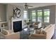 Cozy living room with a fireplace, built-in shelves, and large windows at 4026 Overcup Oak Ln, Cary, NC 27519