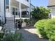 Back patio featuring brick pavers, a stone planter, mature landscaping, and cafe string lights at 4026 Overcup Oak Ln, Cary, NC 27519