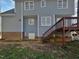 View of the blue siding and wood stairs leading to the back entry of this home at 4507 Lazyriver Dr, Durham, NC 27712