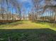 Expansive backyard featuring a lush, green lawn and mature trees in a fenced yard at 4507 Lazyriver Dr, Durham, NC 27712