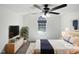 Well-lit main bedroom features a ceiling fan, a window and a bed with white sheets and a blue throw at 4507 Lazyriver Dr, Durham, NC 27712