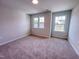 Light filled bedroom with neutral walls, carpeted floors, and two large windows at 452 Duncan Creek Rd # 156, Lillington, NC 27546