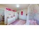 Bright and spacious bedroom features a canopy bed and a dresser with unique decorations on the walls at 507 Southwick Pl, Mebane, NC 27302
