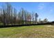 Picture of the large backyard with mature trees and a dark wood fence at 511 Mcarthur Rd, Broadway, NC 27505