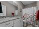 Modern bathroom has granite countertop, white cabinets, and a decorative floral shower curtain at 511 Mcarthur Rd, Broadway, NC 27505