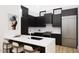 Modern kitchen with a large island, stainless steel appliances, and black cabinets at 512 Gordon St # 404, Durham, NC 27701