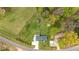Aerial view of a home with a large grassy yard, mature trees, and a long driveway with parking at 5121 Leesville Rd, Durham, NC 27703