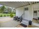 Charming back porch with seating, a welcome mat, and a view of the landscaped backyard and detached garage at 5121 Leesville Rd, Durham, NC 27703