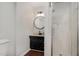 Updated bathroom with a dark vanity, round mirror, and glass enclosed walk-in shower at 5121 Leesville Rd, Durham, NC 27703