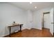 Bedroom featuring hardwood floors, neutral paint, a console table, and a door leading to an adjoining room at 5121 Leesville Rd, Durham, NC 27703