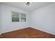 Bedroom featuring hardwood floors, a large window with blinds, and neutral paint, creating a serene atmosphere at 5121 Leesville Rd, Durham, NC 27703